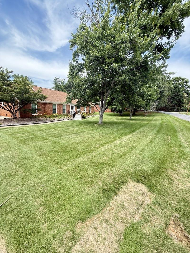Brick property with landscaped beds and striped front lawn