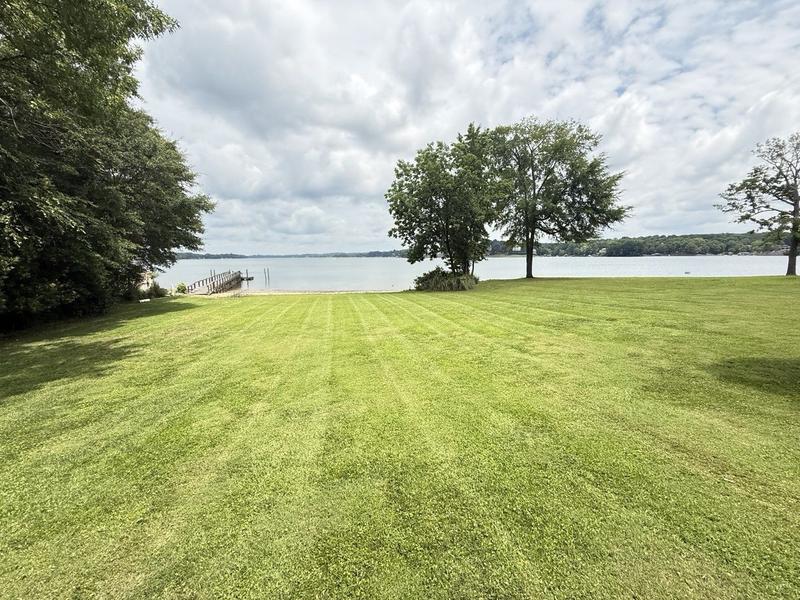 Striped lakefront lawn running down to a dock on the water